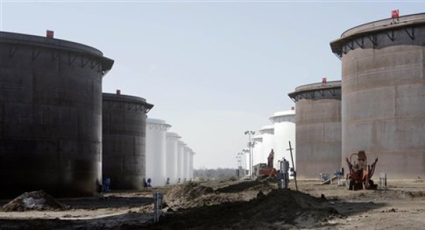 This March 13, 2012 photo shows older and newly constructed 250,000 barrel capacity oil storage tanks at the SemCrude tank farm north of Cushing, Okla. For the past seven weeks, the United States has been producing and importing an average of 1 million more barrels of oil every day than it is consuming. That extra crude is flowing into storage tanks, especially at the country