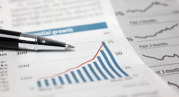 Close-up on ball-point pen and newspaper financial stock chart.