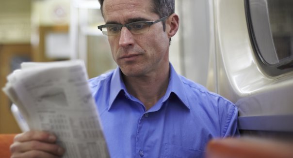 Man Reading Newspaper On Subway