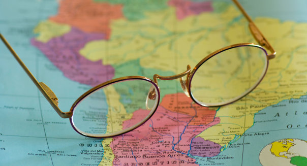 closeup of reading glasses on map of South America