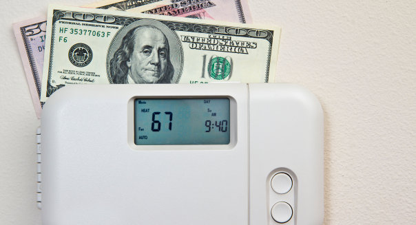 In door heating thermostat set at a room temperature and money